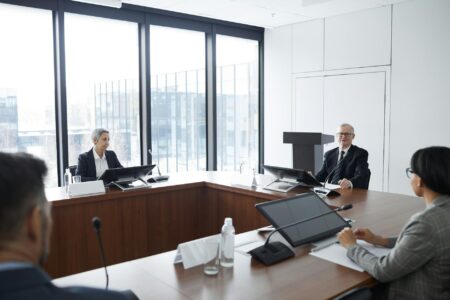 Professional business meeting in modern conference room with executives discussing strategy