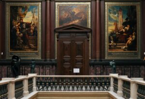 Elegant art museum gallery with paintings on walls and visitors viewing exhibitions