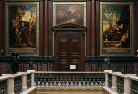 Elegant art museum gallery with paintings on walls and visitors viewing exhibitions