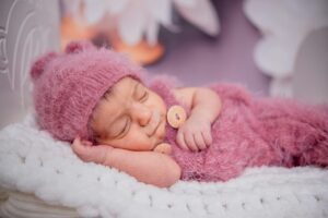 How Professional Sleep Consultants Became Essential for New Parents Peaceful sleeping infant in white bedding demonstrating successful sleep training results