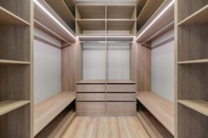 How Professional Decluttering Services Became Essential for Downsizing Executives Professional organizer arranging clothes in a minimalist walk-in closet with efficient storage solutions