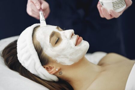 Professional esthetician performing facial treatment with modern skincare device