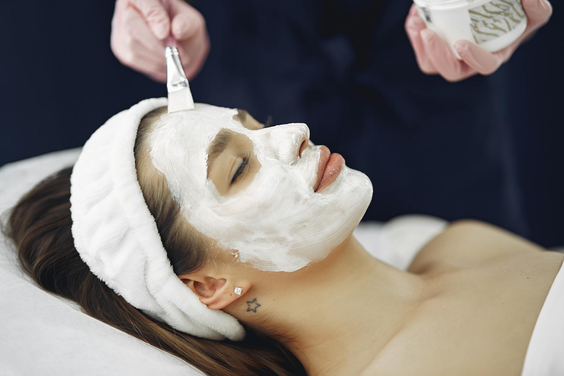Professional esthetician performing facial treatment with modern skincare device