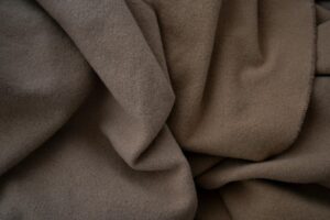 Soft cashmere fabric in neutral tones showcasing the luxurious texture of sustainable cashmere