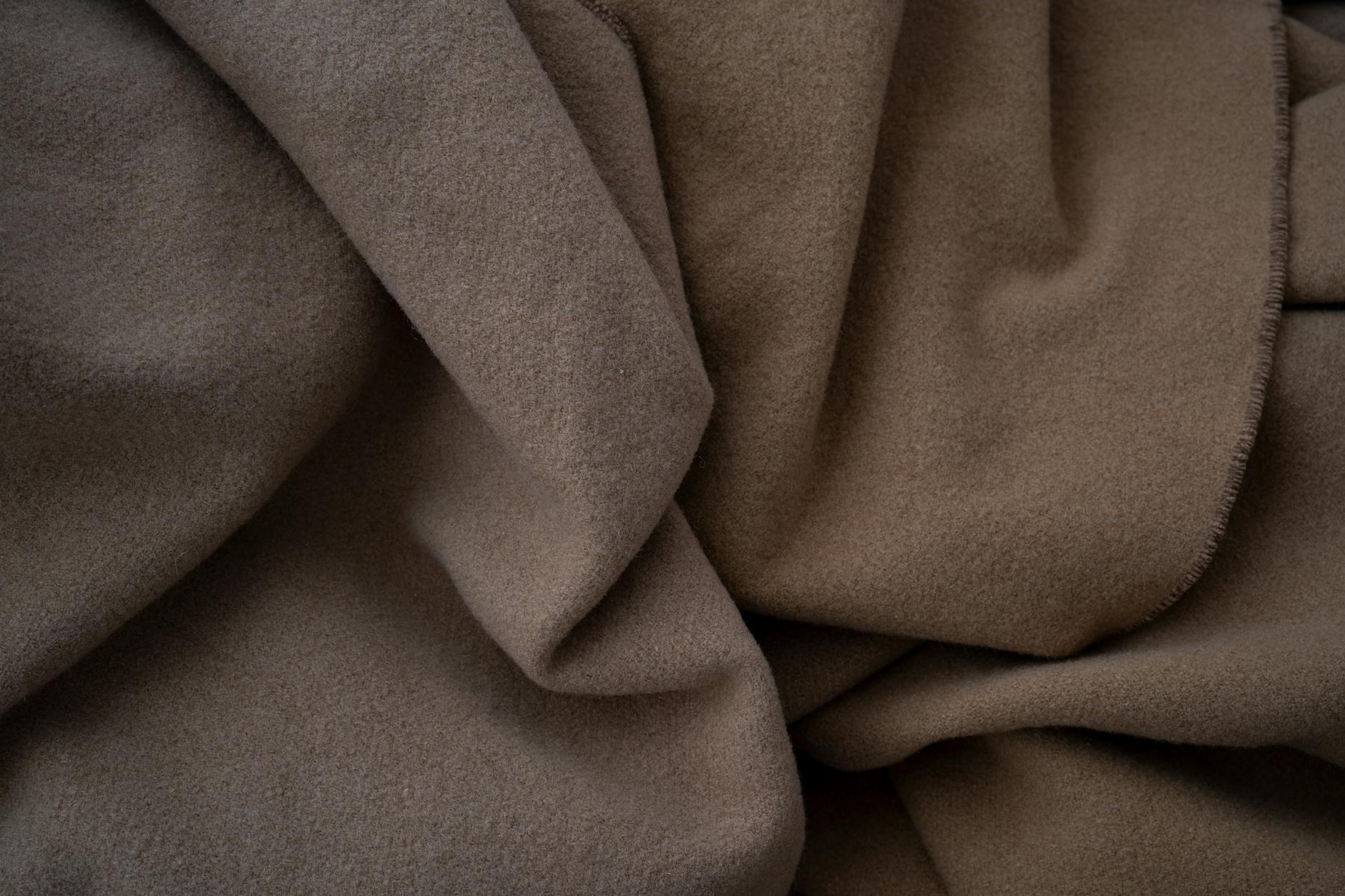 Soft cashmere fabric in neutral tones showcasing the luxurious texture of sustainable cashmere