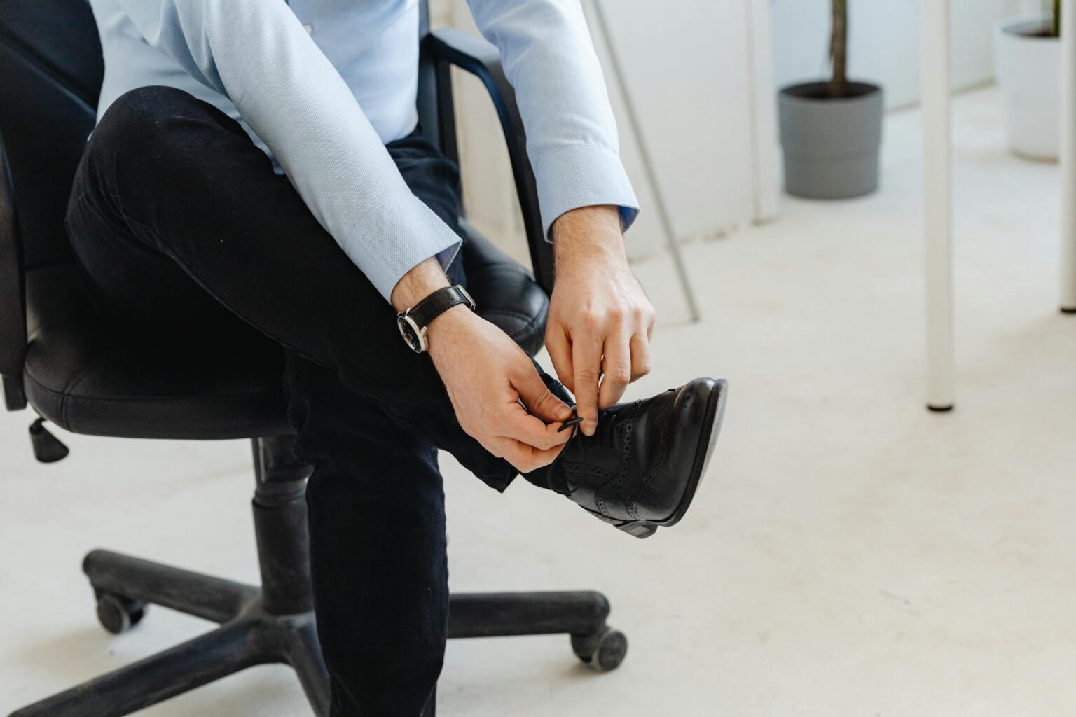 Professional black dress shoes arranged on wooden floor representing executive footwear choices