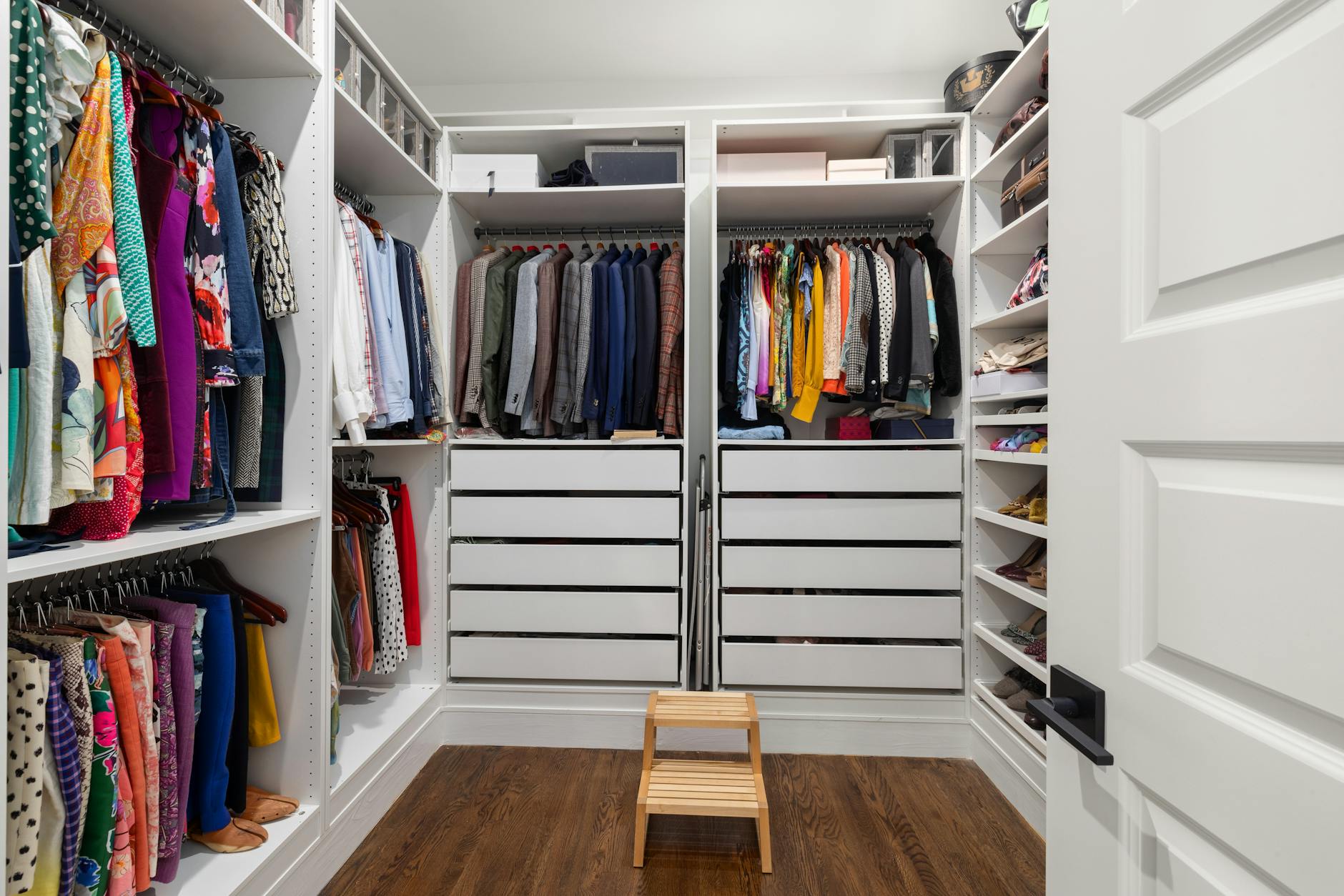 Well-organized professional closet with neatly arranged suits, shirts, and accessories