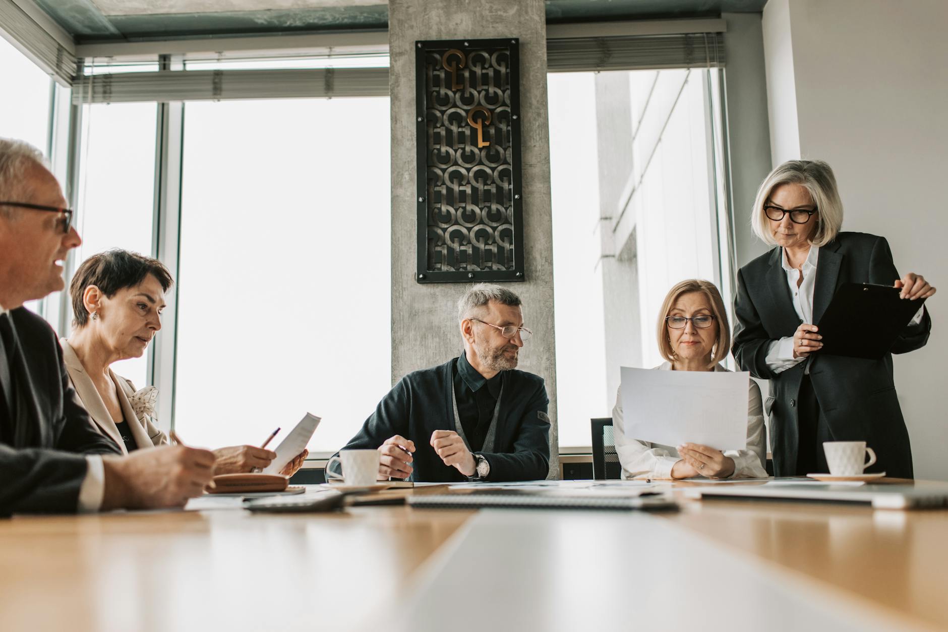 Professional business meeting in modern boardroom with people in business attire