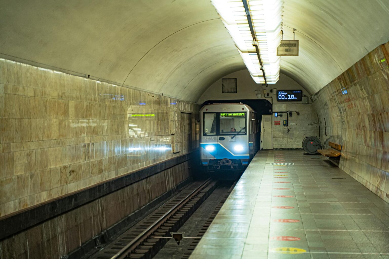 Empty subway station platform with tiled walls and vintage architecture