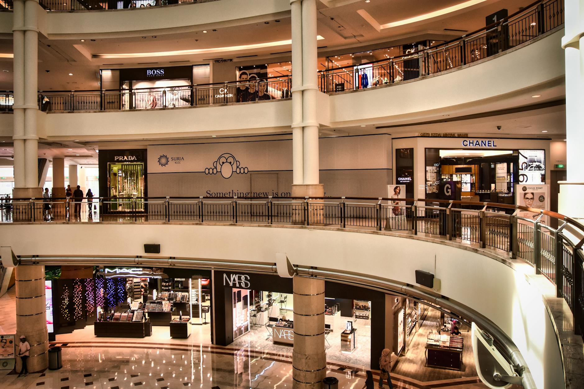 Teenager browsing clothing in upscale shopping mall with shopping bags