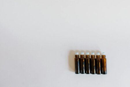 Various essential oil bottles and droppers arranged on natural wooden surface
