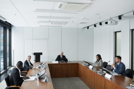 Professional business meeting in modern conference room with people in business casual attire