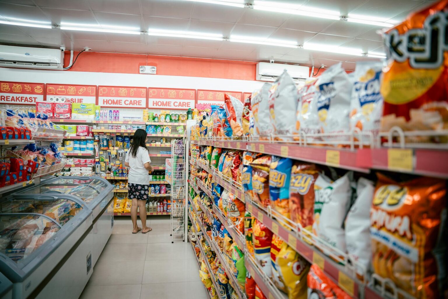 Bright grocery store aisle with fluorescent lighting and product displays creating potential runway space