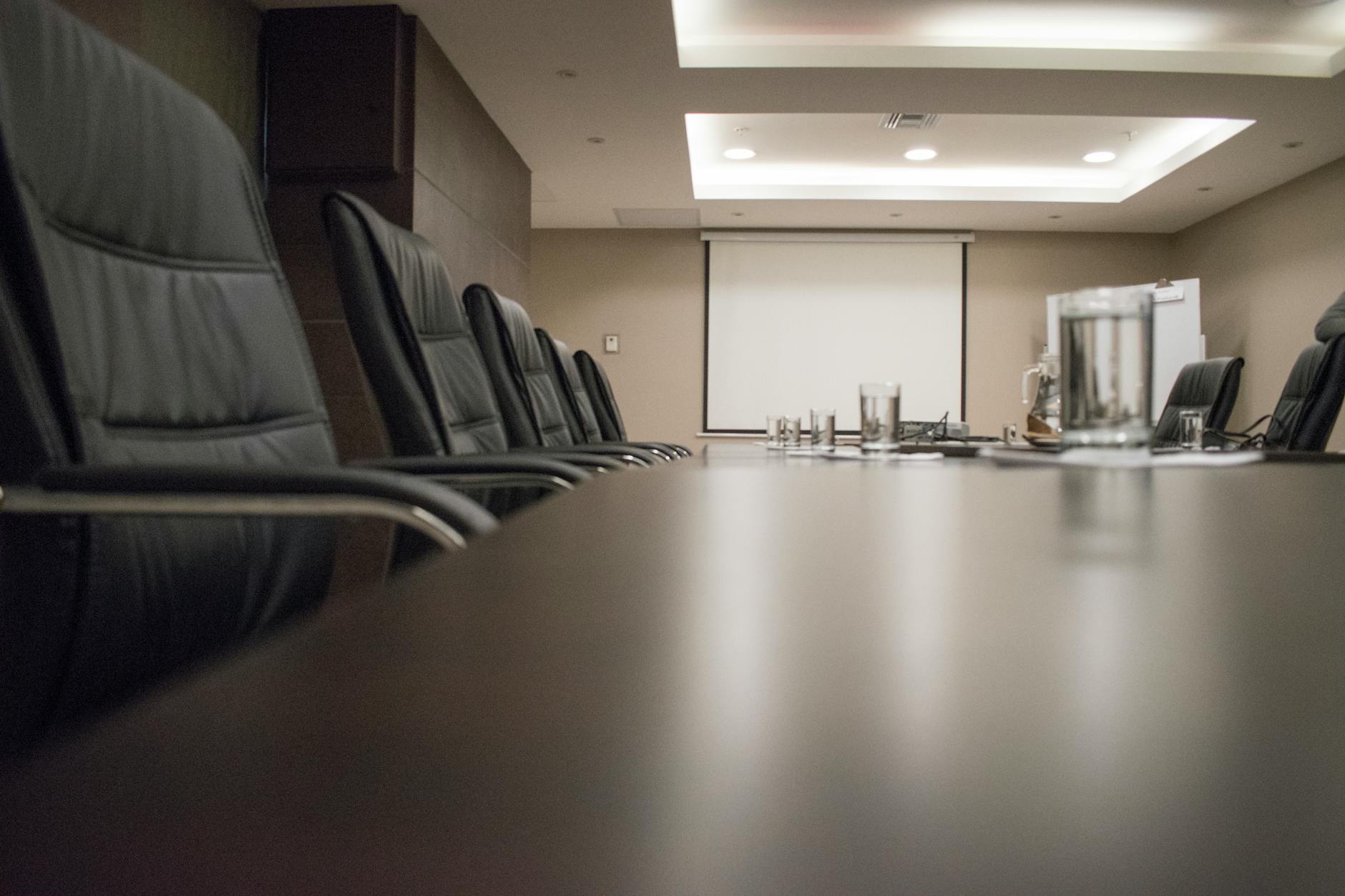 Modern corporate boardroom with conference table and chairs where executives make footwear decisions