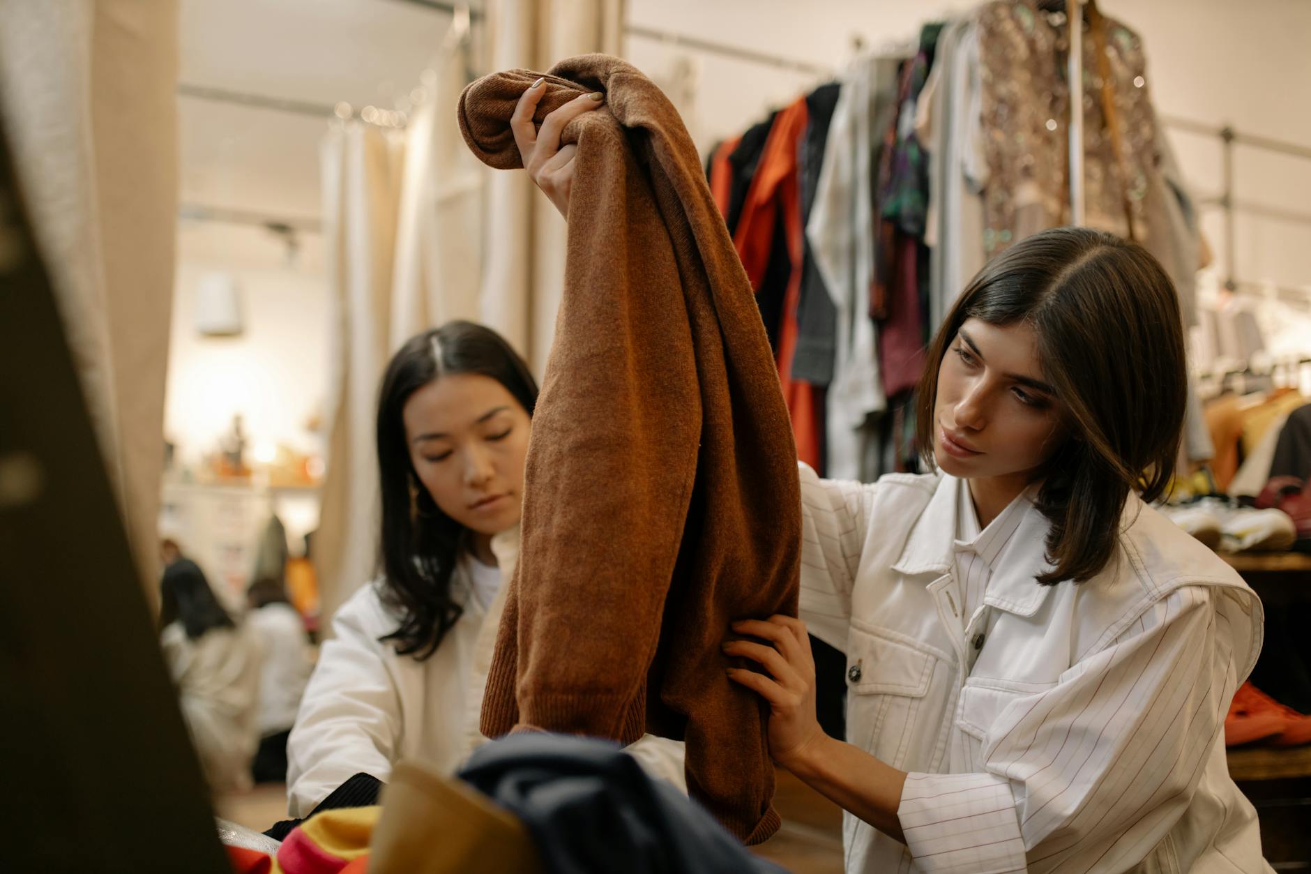 Woman browsing through clothing racks in thrift store searching for vintage pieces