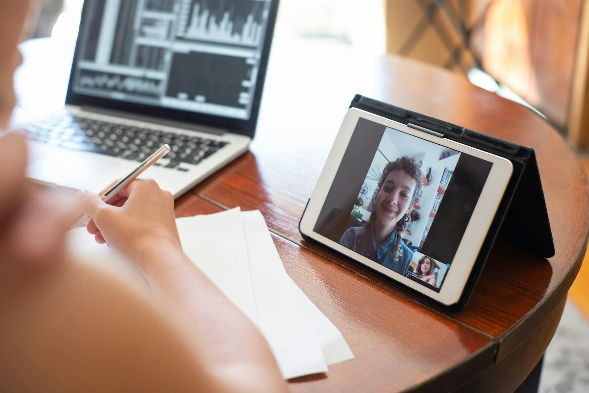 Person in professional blazer participating in video conference call from home office