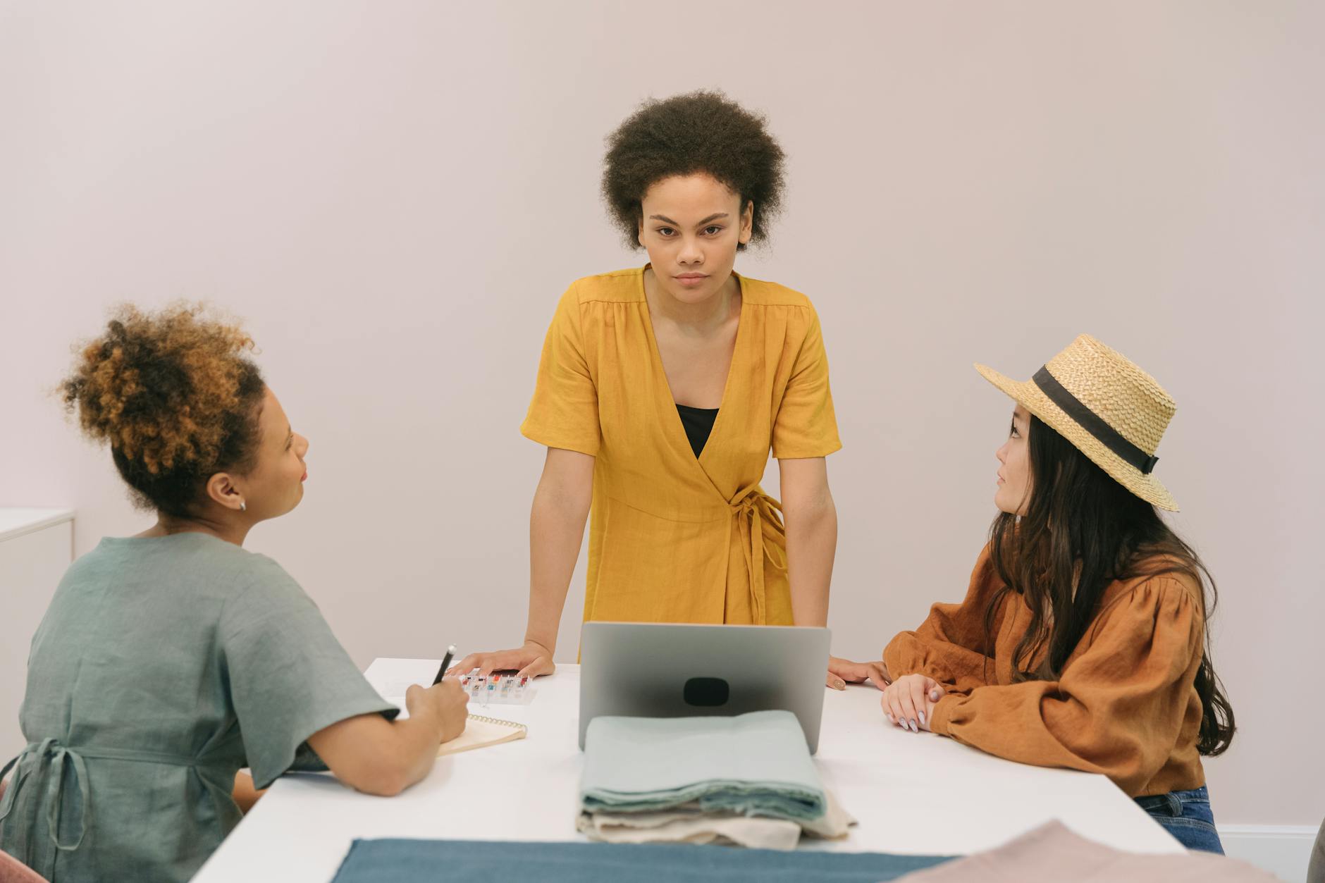 Creative professionals in blazers collaborating around conference table during business meeting