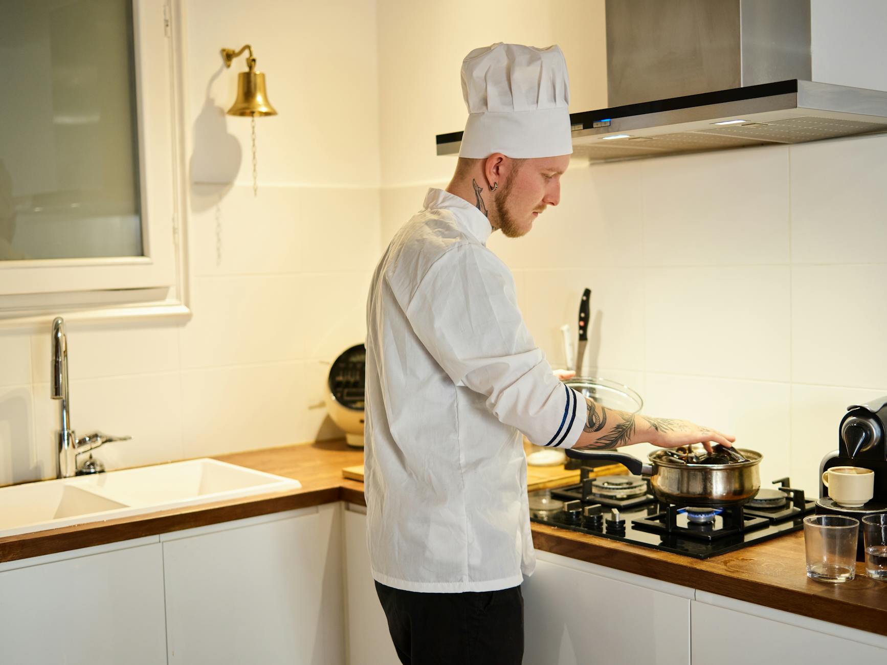 Chef preparing food in commercial kitchen wearing professional uniform