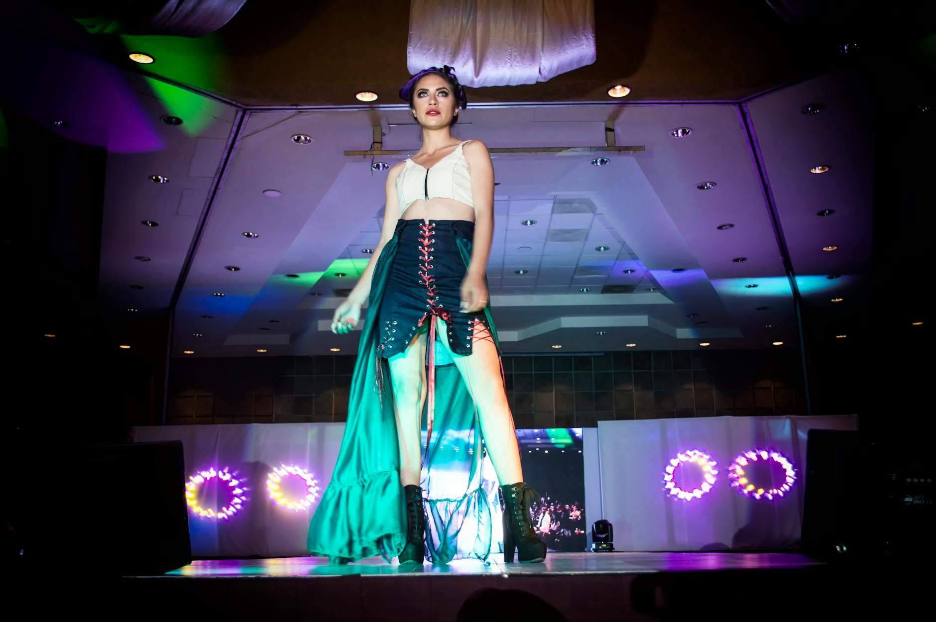 Fashion runway show with models walking down catwalk in dramatic lighting