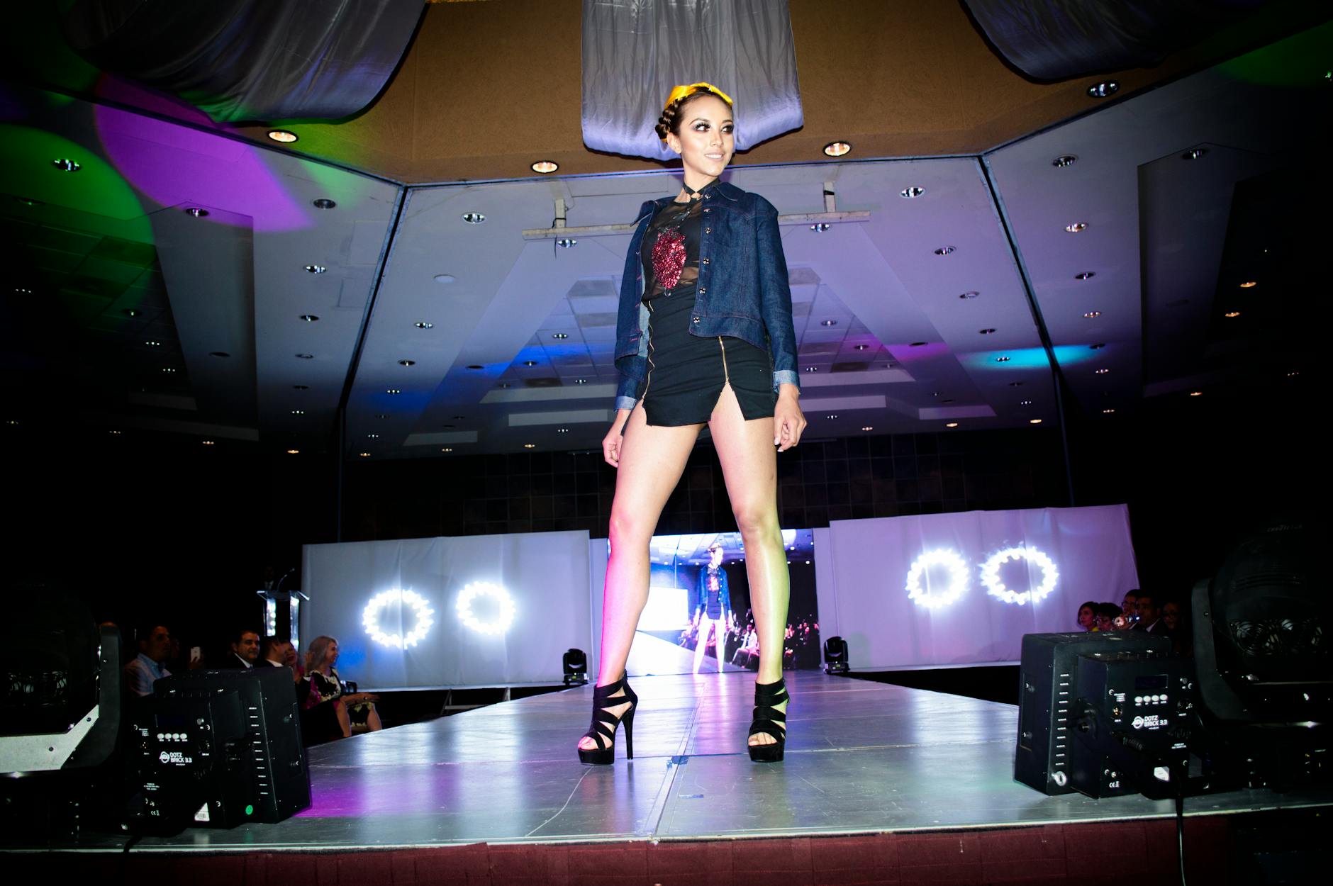 Models walking on fashion runway with audience watching from sides