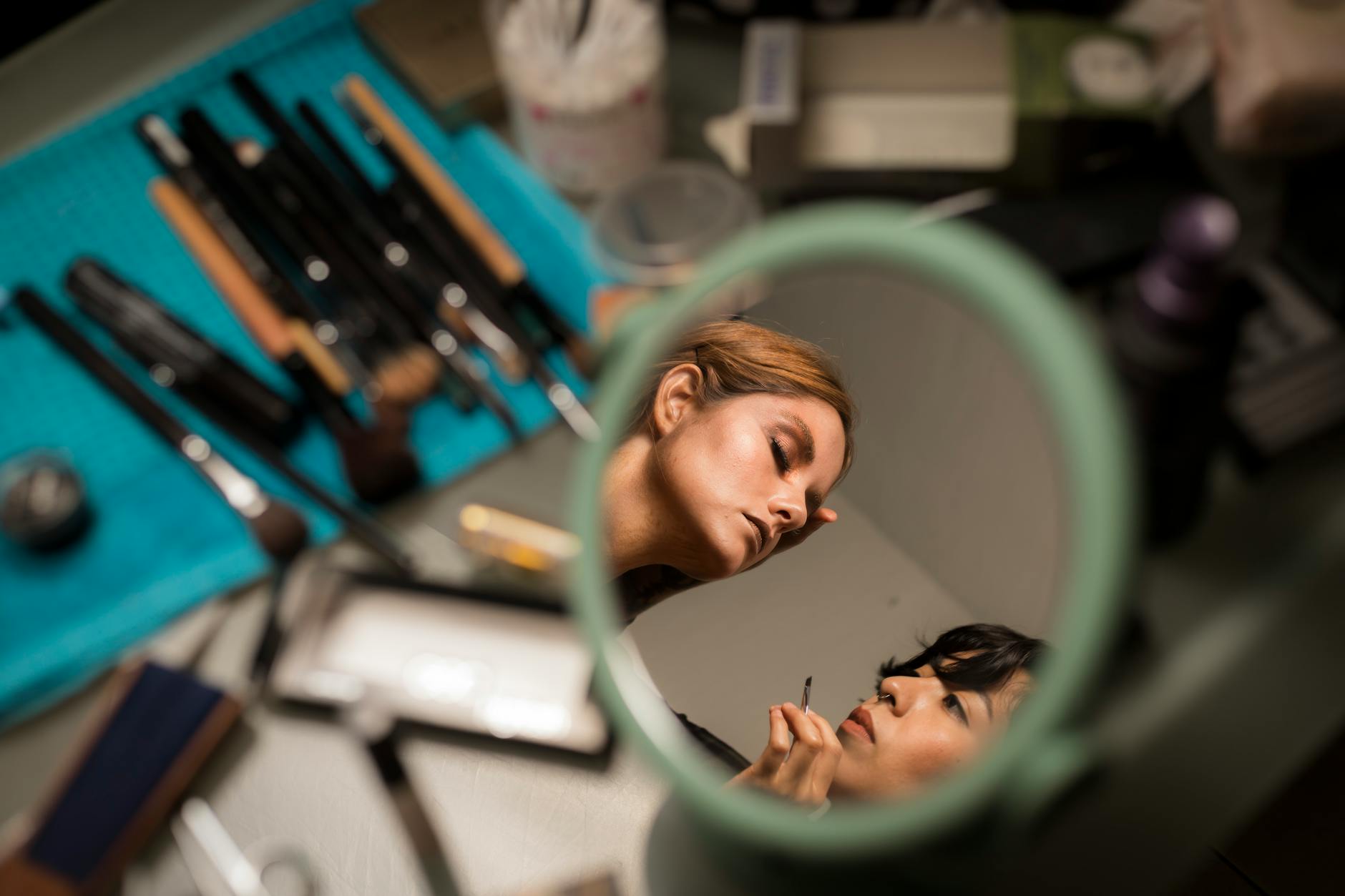 Professional makeup artist applying skincare treatment to client's face in studio setting