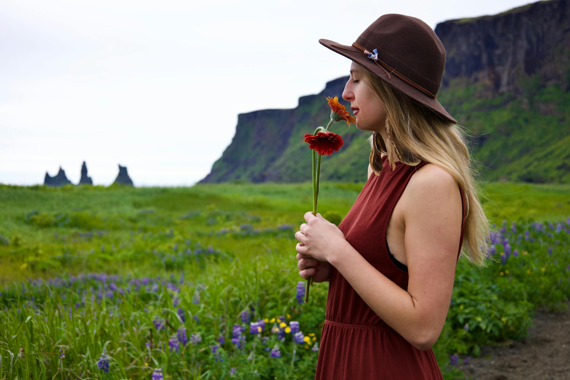 Woman with closed eyes smelling white flowers, capturing sensory experience of fragrance creation