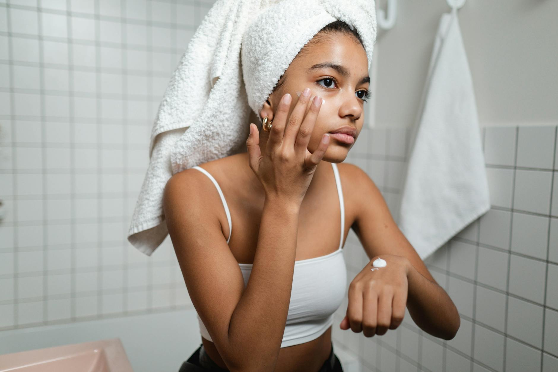 Woman gently applying anti-aging cream to her face demonstrating sensitive skincare routine