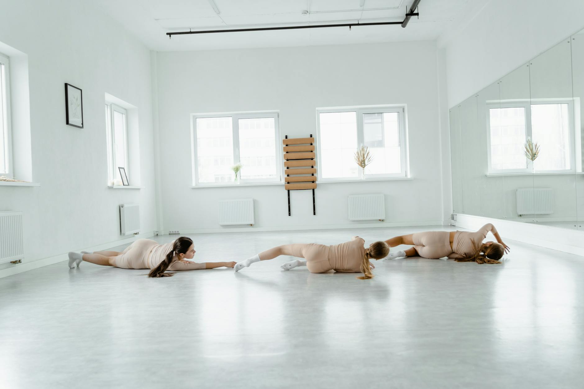 Ballet dancers rehearsing in a professional studio wearing modern athletic shoes during training session