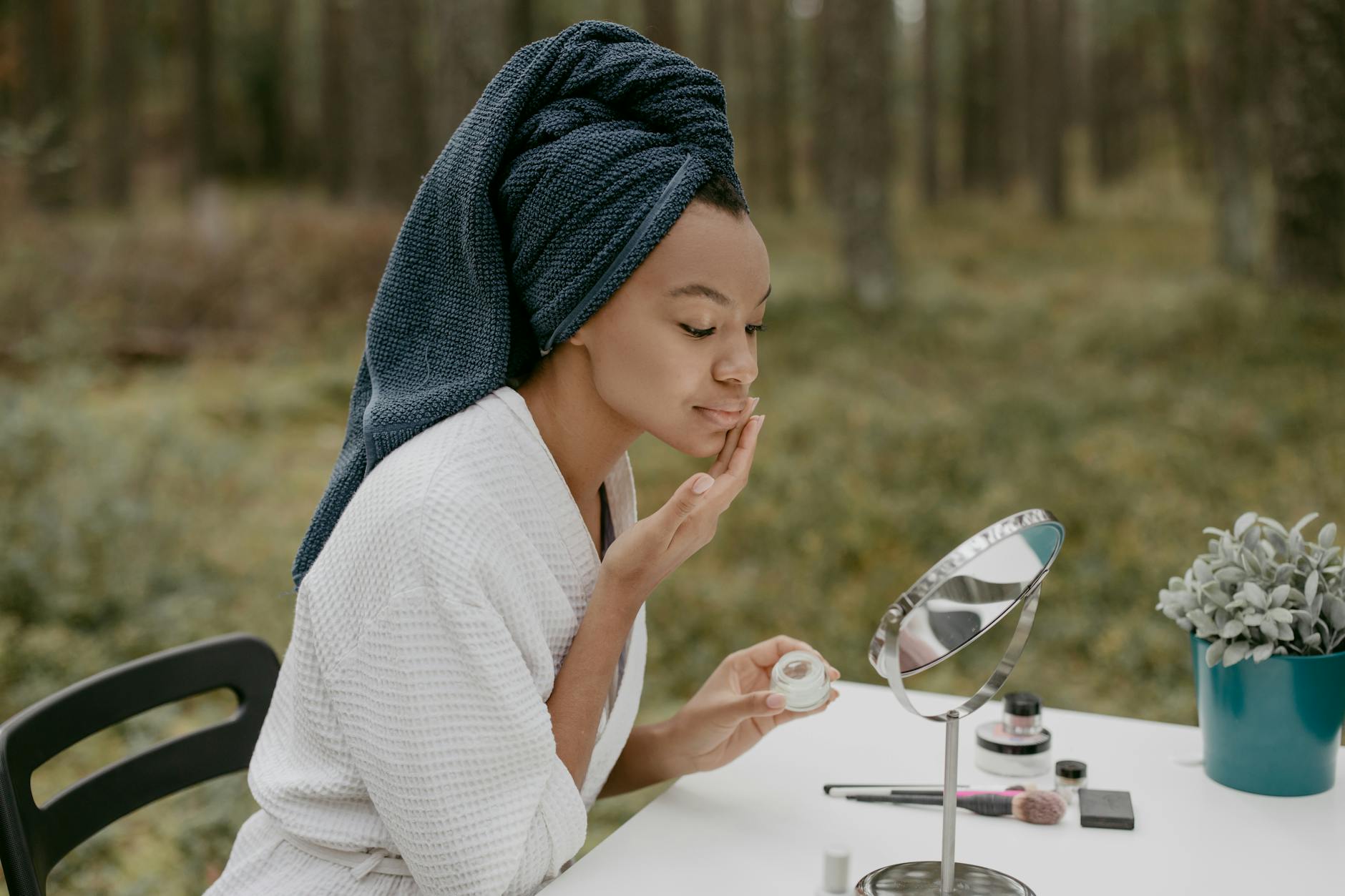 Woman performing skincare routine in bathroom mirror