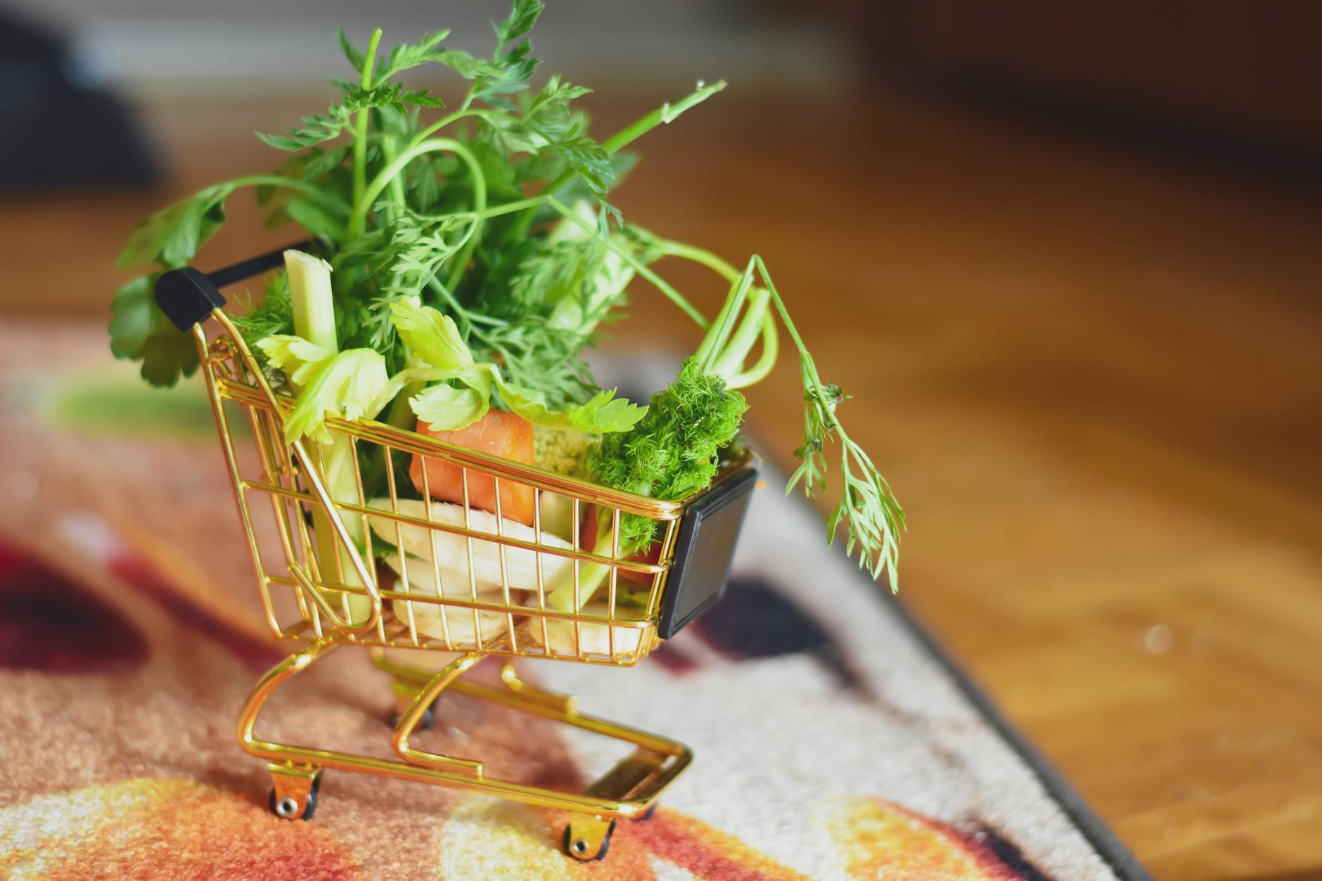 Shopping cart in grocery store produce section with fresh vegetables