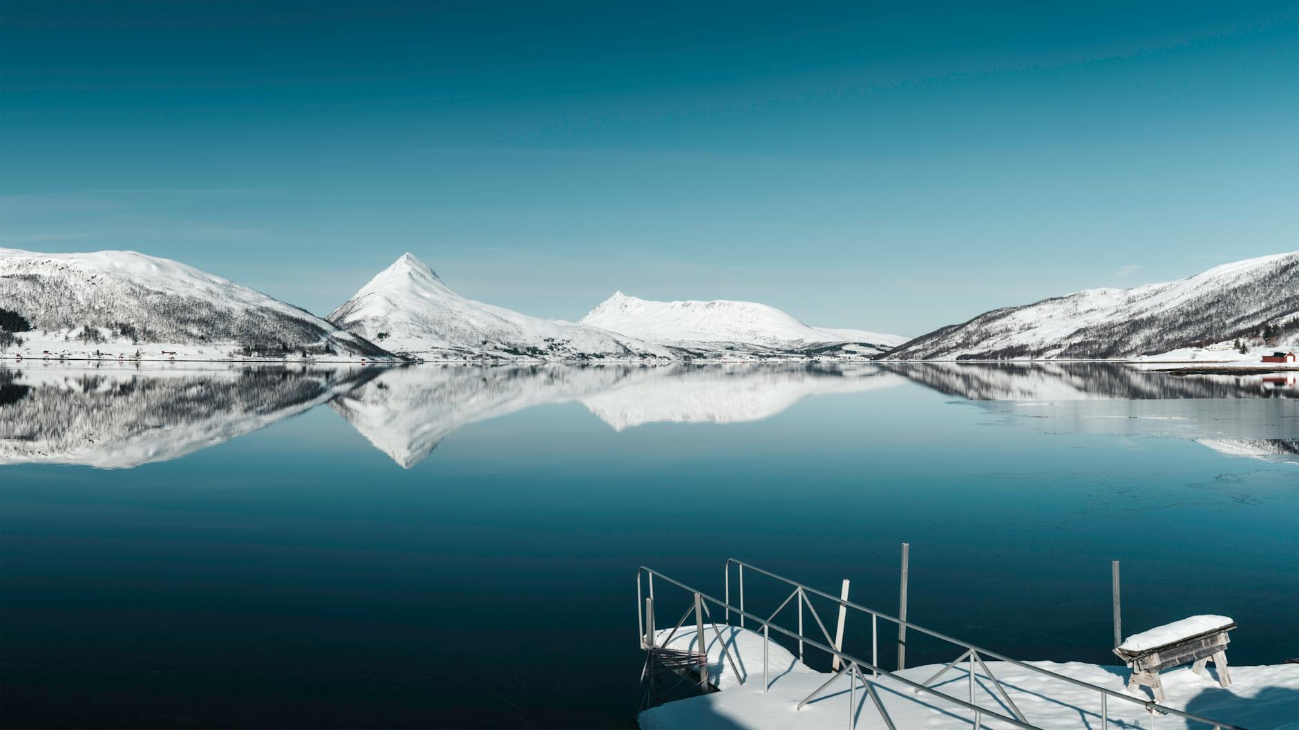 Stunning arctic winter landscape with snow-covered terrain and dramatic northern lighting conditions