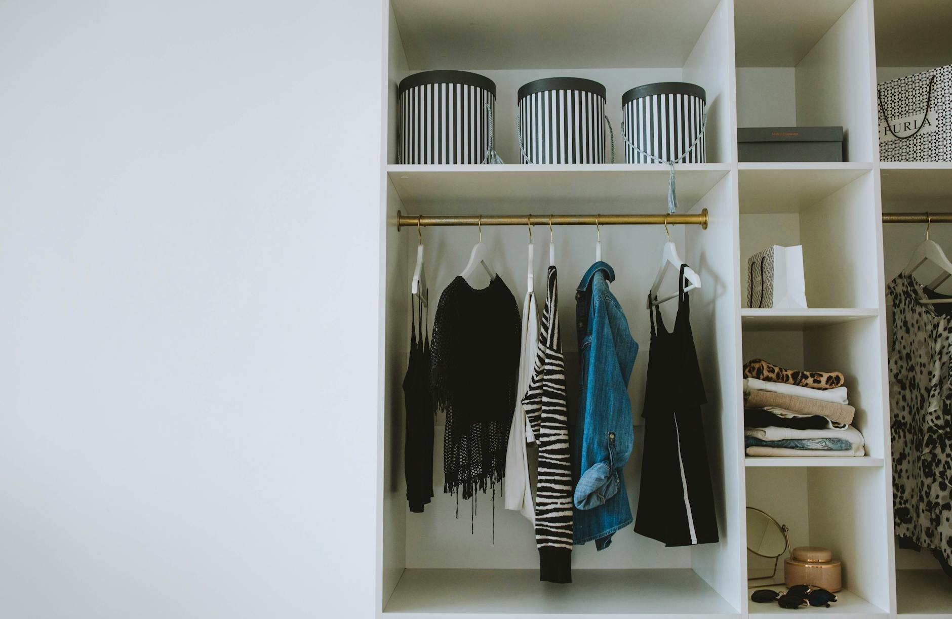Well-organized walk-in closet with neatly arranged clothing and accessories