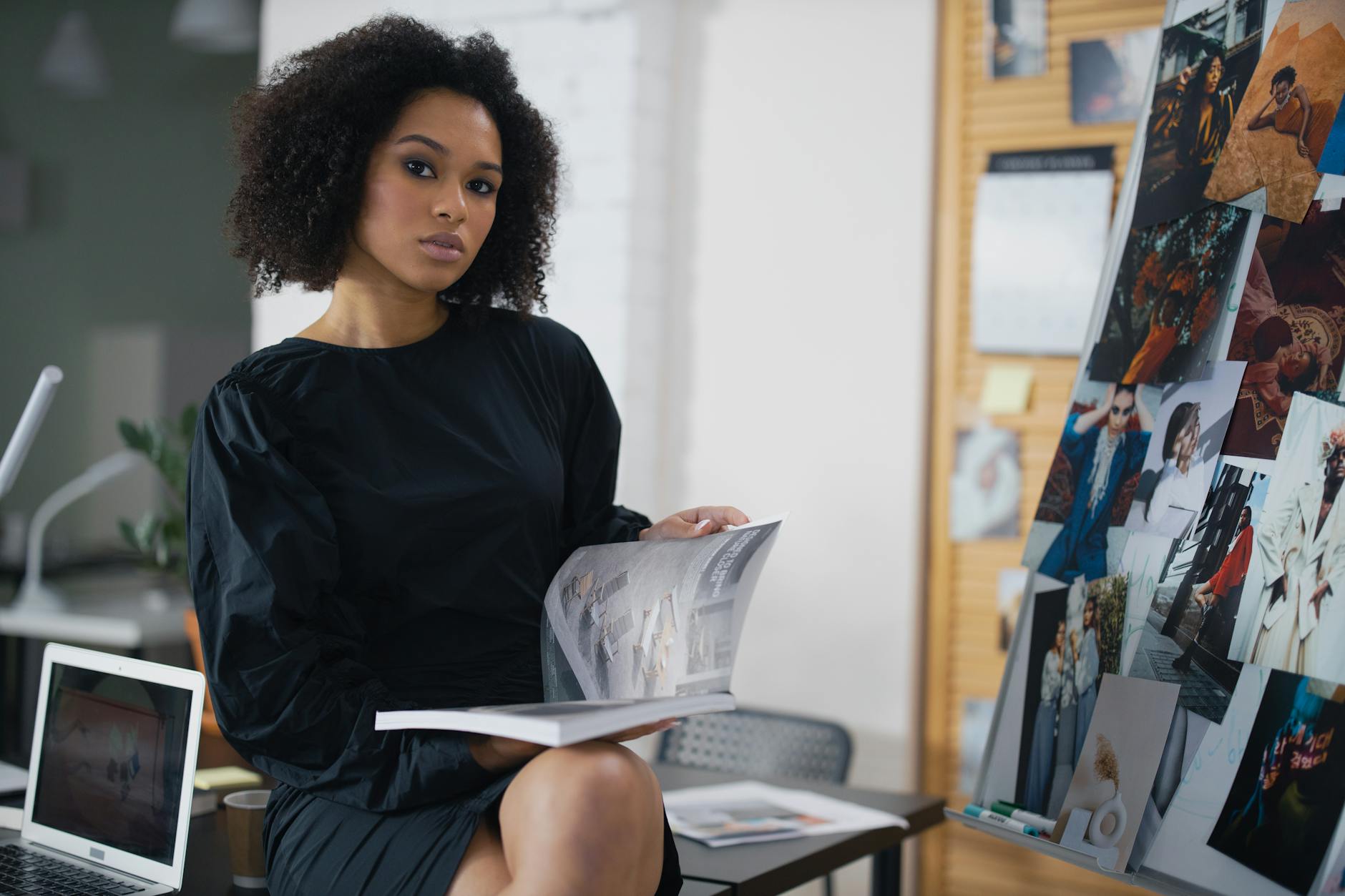 Professional woman in stylish outfit reviewing fashion materials in modern office setting
