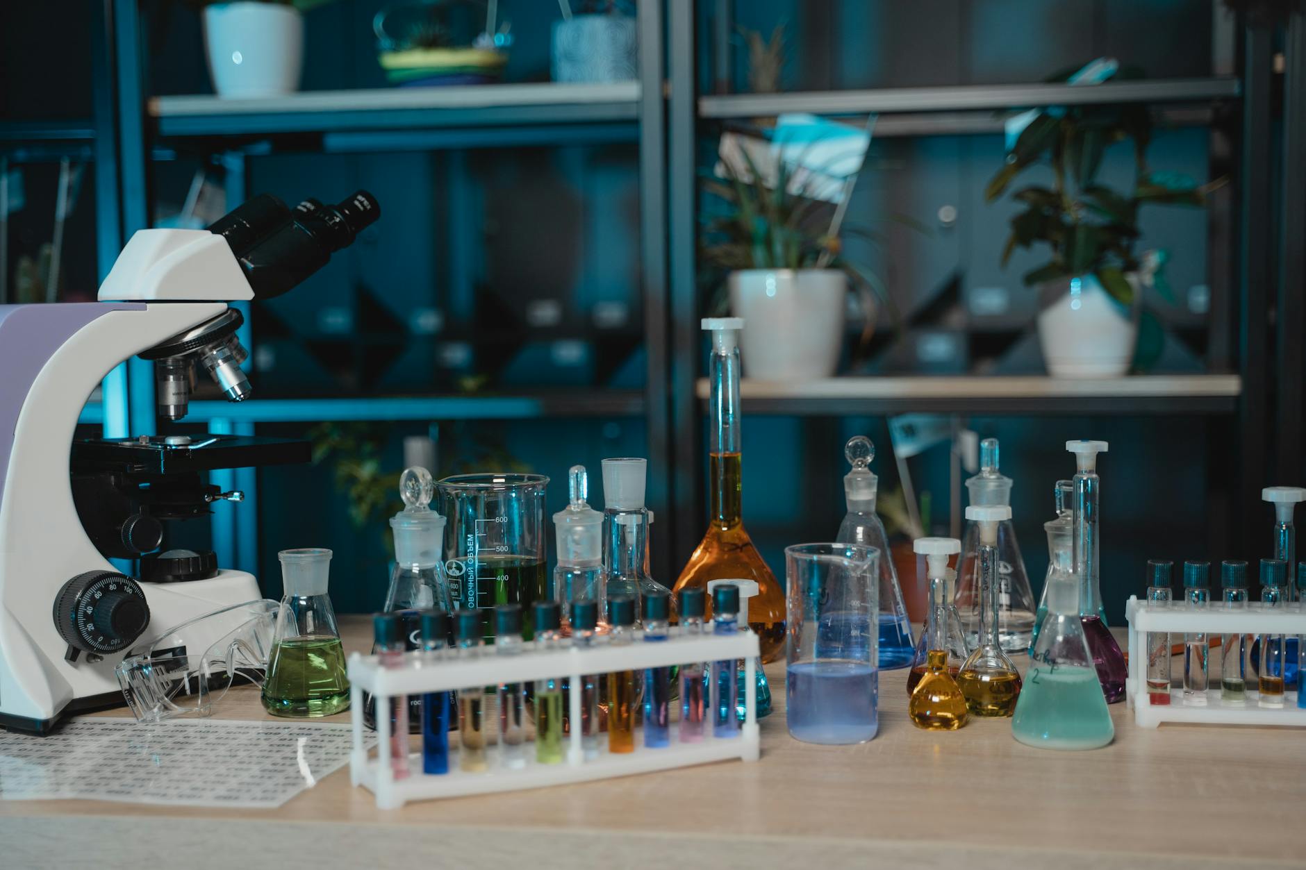 Scientific laboratory beakers with colorful liquids representing perfume blending and formulation process