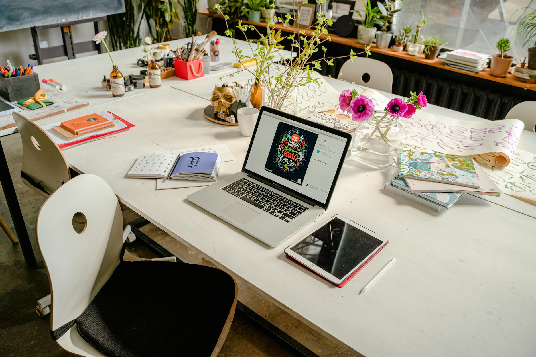 Artist working in creative studio space with sketches and design materials