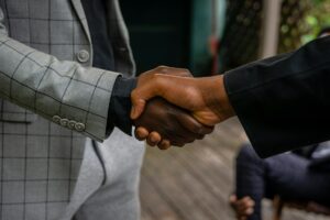 Ground Up International Shifts Strategy With Dickies, Scotch & Soda Deals Business professionals shaking hands over partnership agreement