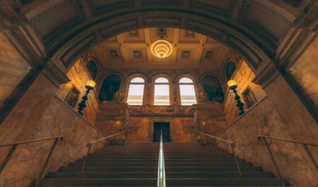 Ornate gilded hall inside a historic French palace with chandeliers and painted ceilings