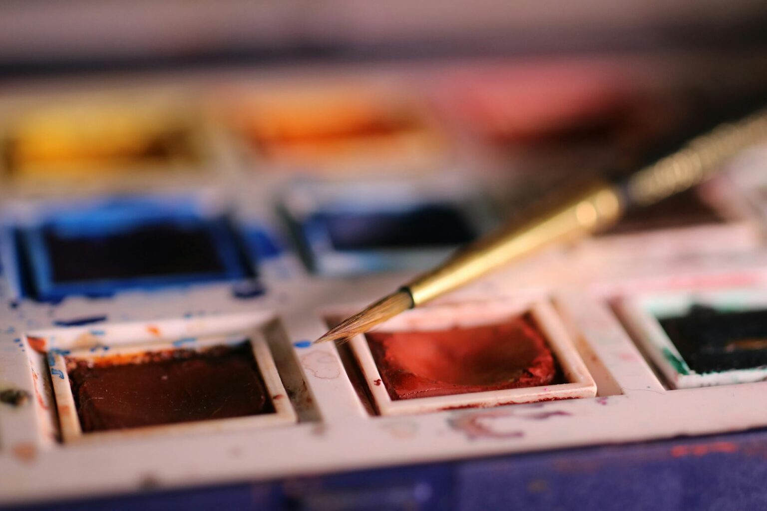 Close-up of hands showing watercolor nail art with soft pastel colors blending together