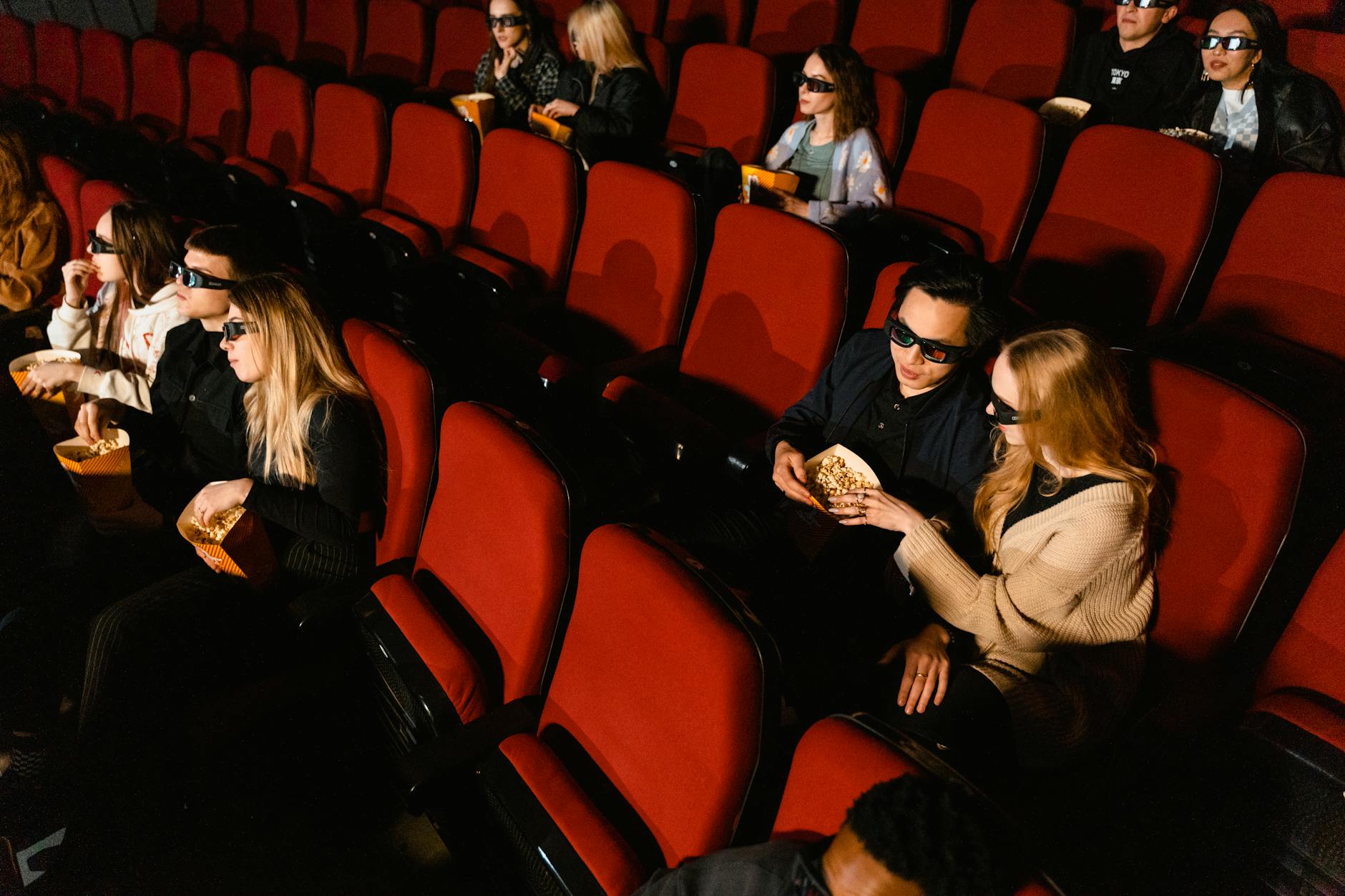 Red velvet cinema seats in darkened movie theater
