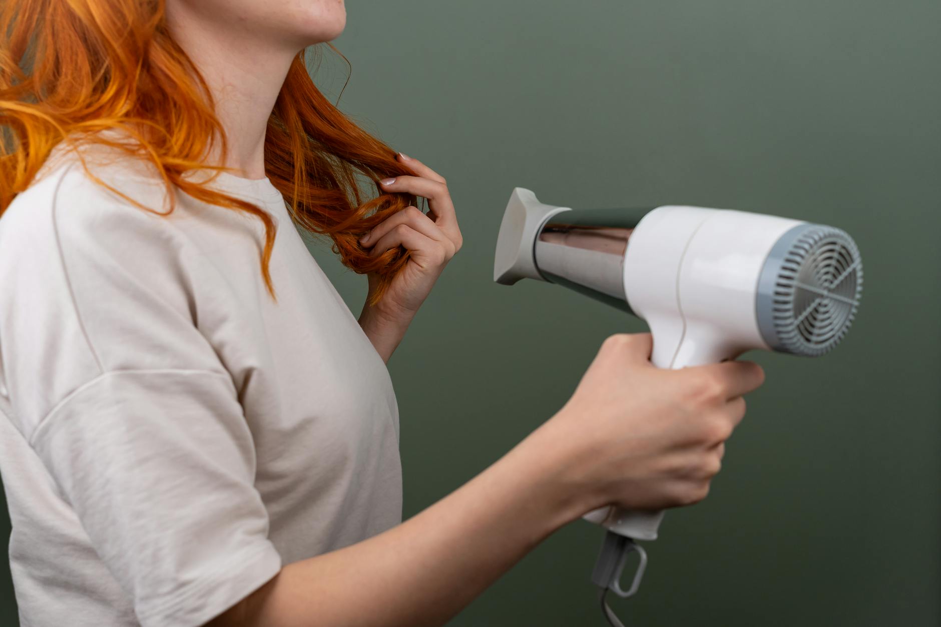 Woman blow drying hair with round brush for volume and lift