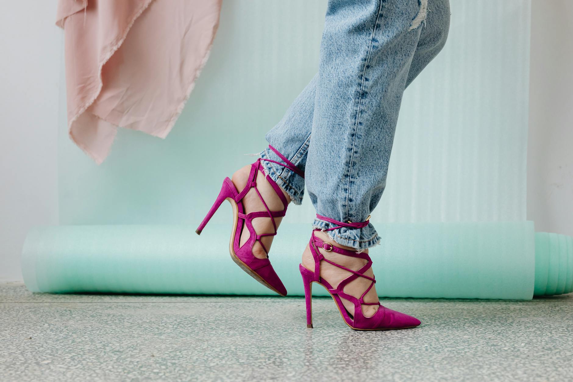 Close-up of a python-textured stiletto pump heel on a glossy surface