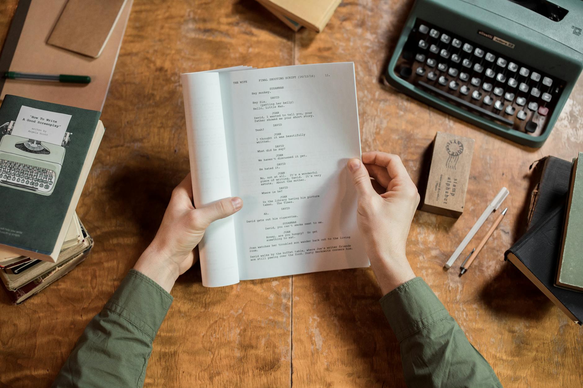 Movie script pages spread on desk with coffee cup and pen