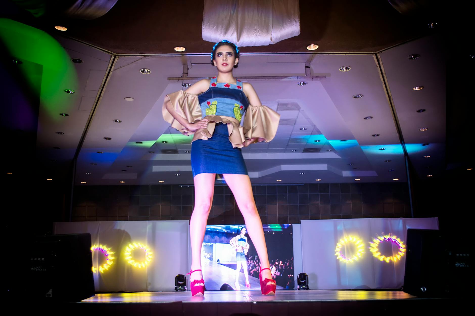 Fashion model walking down runway with dramatic lighting