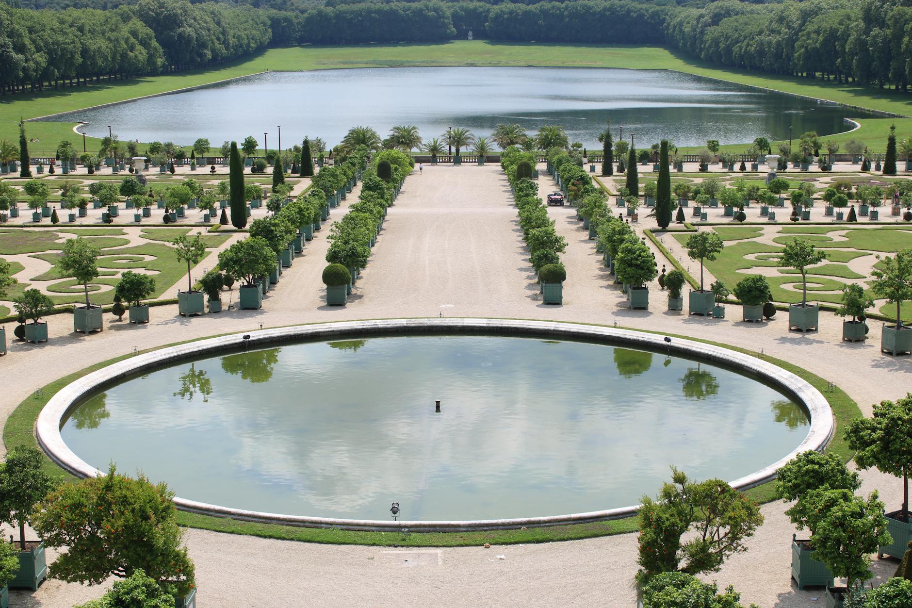 Formal French garden with geometric hedgerows and classical stone fountains at a royal palace