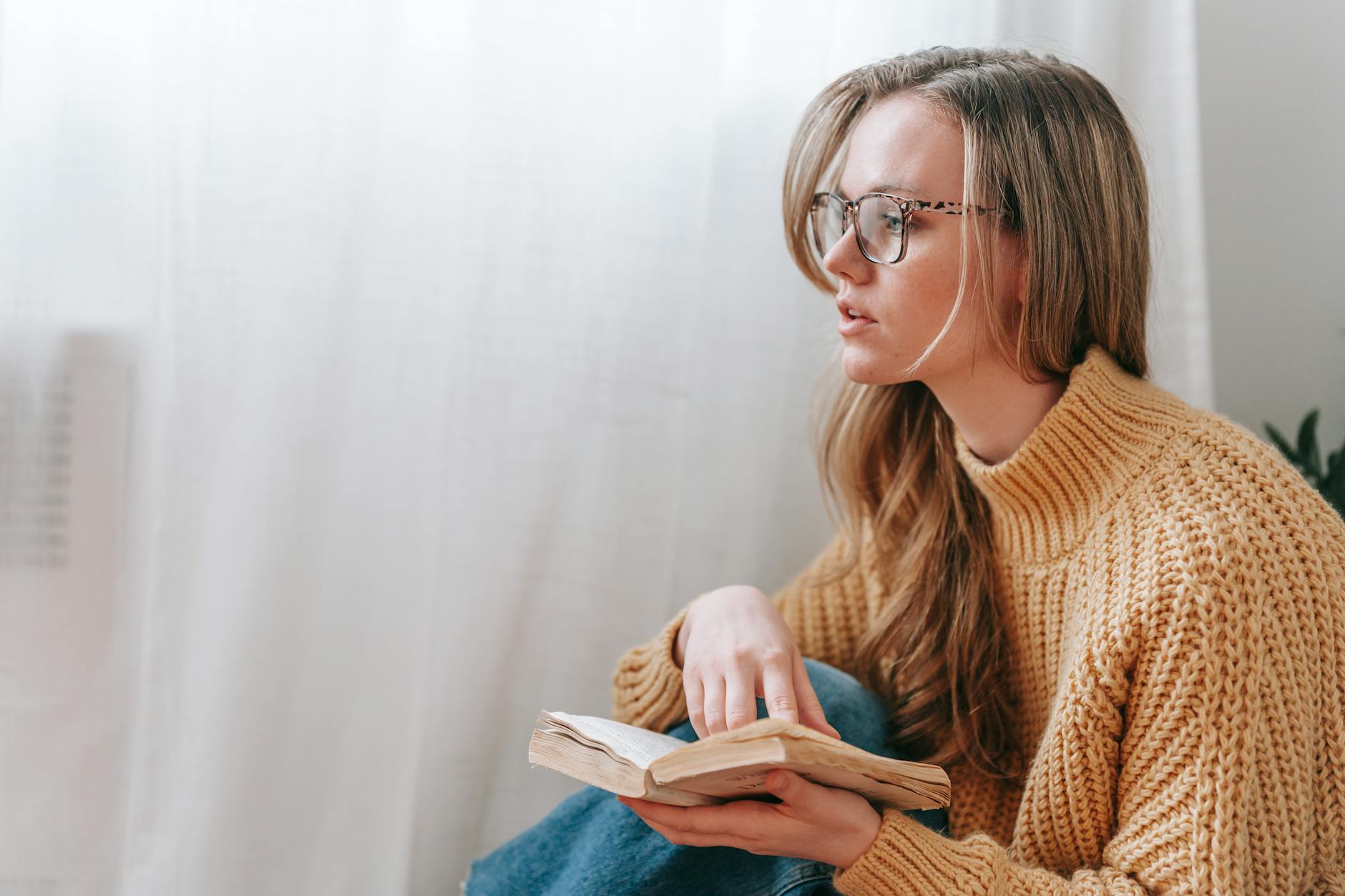 Young woman sitting quietly, thoughtful expression, watching something off-screen