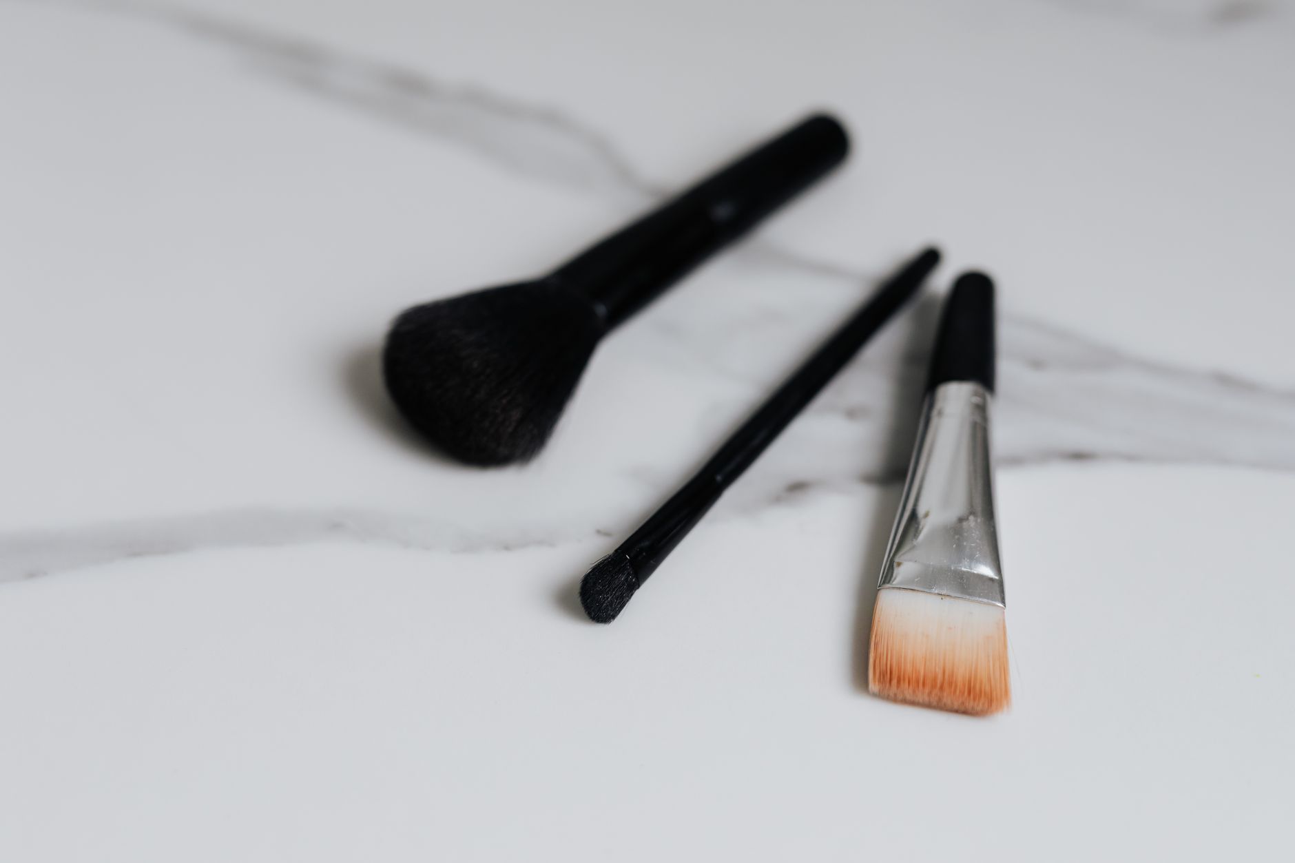 Soft makeup brushes and blush palette arranged on a flat surface
