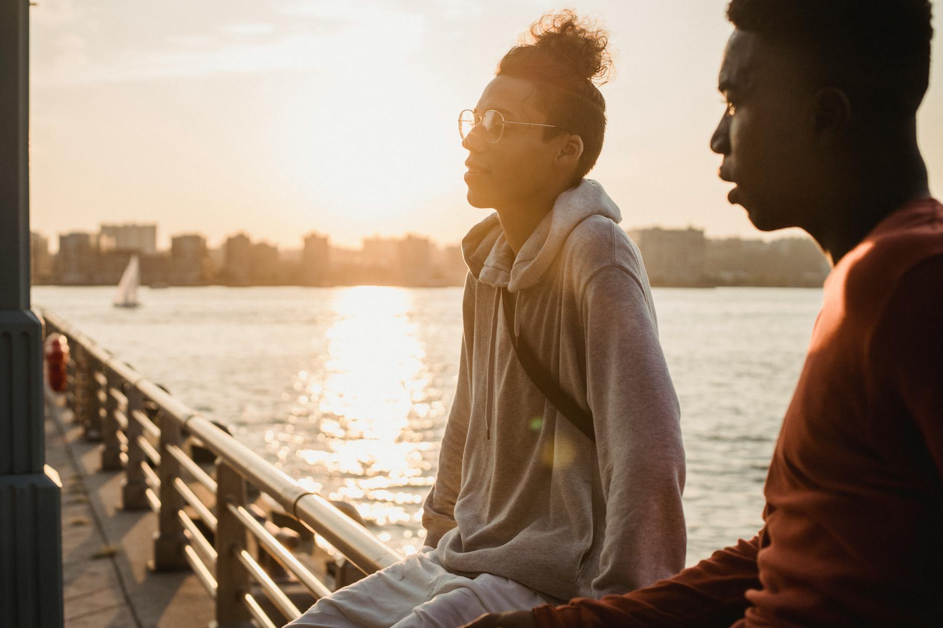 Two people in conversation outdoors during golden hour sunset light