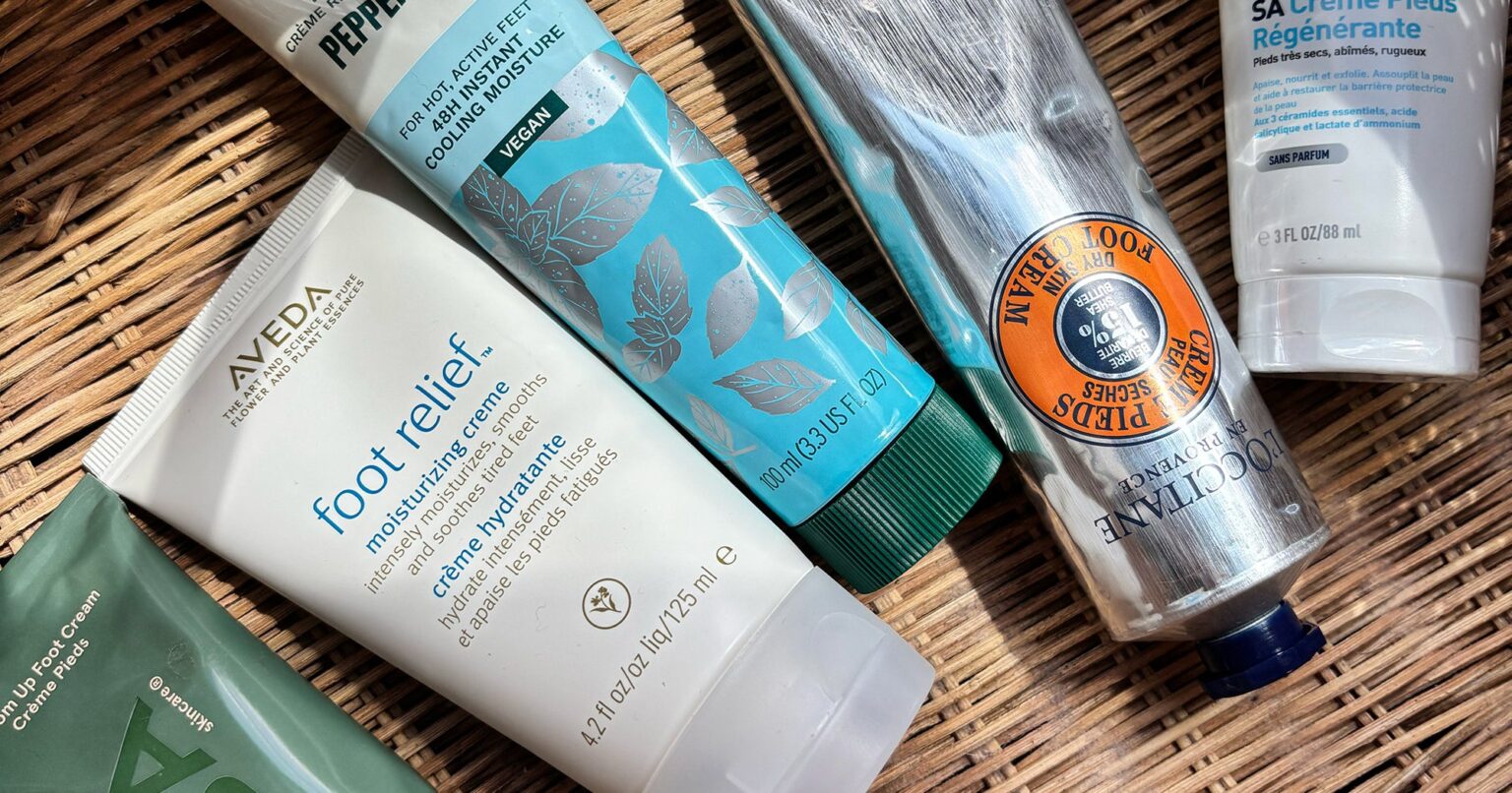 Various foot cream tubes and jars arranged on white surface
