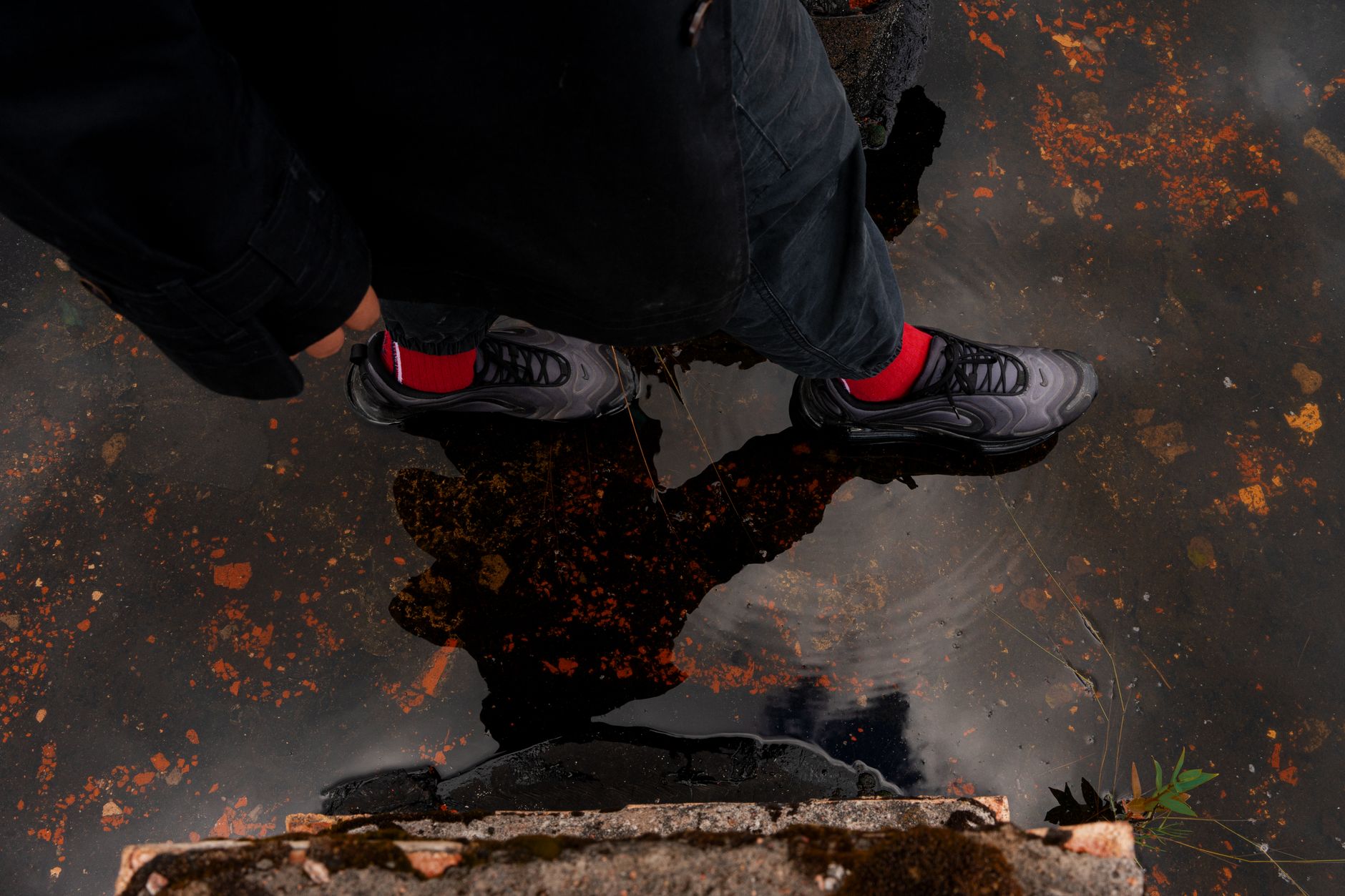Rugged outdoor-style sneakers on a textured terrain surface representing gorpcore fashion trend