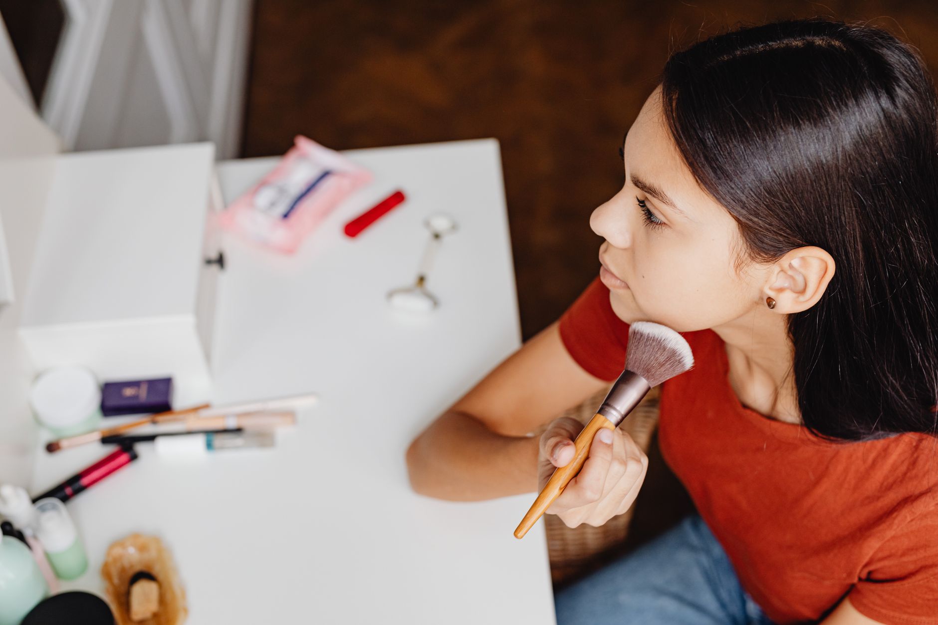 Woman blending lightweight tinted product onto her skin in natural light